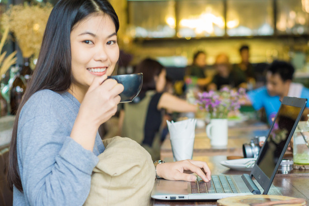 souriant asiatique femmes travailler sur ordinateur portable à café
 - Photo, image