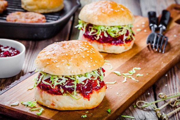 Burgers avec une escalope de dinde, sauce aux canneberges et salade
 - Photo, image