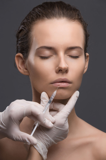 Portrait of young Caucasian woman getting cosmetic injection - Foto, immagini
