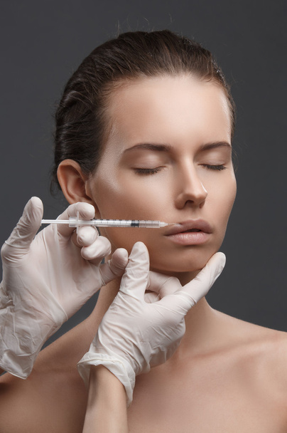 Portrait of young Caucasian woman getting cosmetic injection - Zdjęcie, obraz