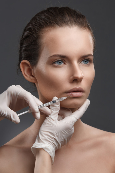 Portrait of young Caucasian woman getting cosmetic injection - Foto, afbeelding