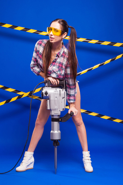 sexy brunette in shorts and goggles on a blue background with a  - Valokuva, kuva