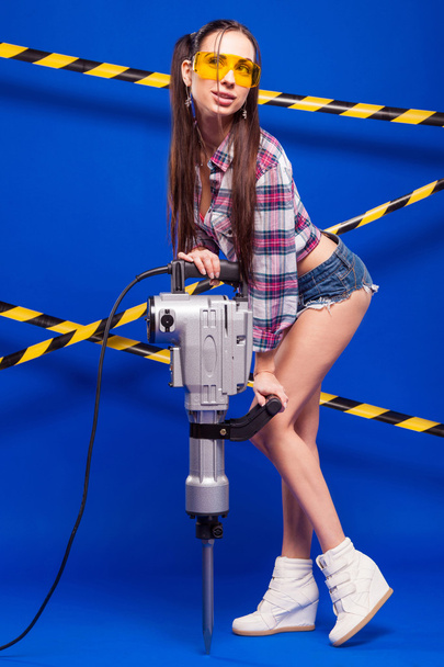 sexy brunette in shorts and goggles on a blue background with a  - Photo, Image