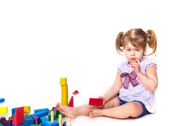 Cute baby girl playing with building blocks isolated  - 写真・画像