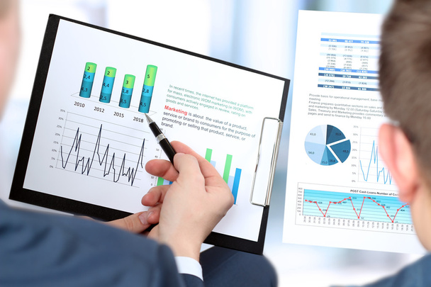 Geschäftskollegen arbeiten zusammen und analysieren Finanzzahlen auf einer Grafik - Foto, Bild