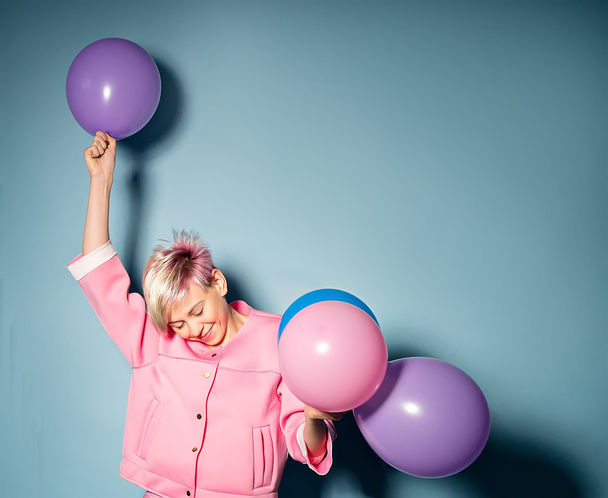 Девушка весело провести время с цветными шариками на синем фоне
 - Фото, изображение