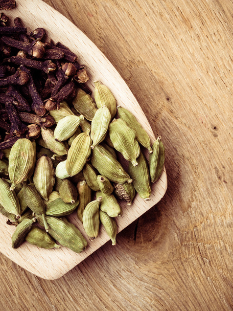 cardamom pods and cloves on wooden spoon - Foto, imagen