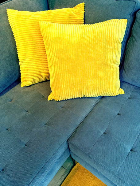 blaues Sofa mit leuchtend gelben Kissen - Foto, Bild