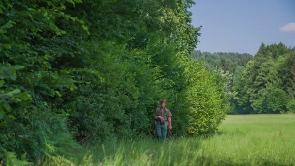 Yakınındaki bir yeşil çim ormanda yürüyüş avcı - Video, Çekim