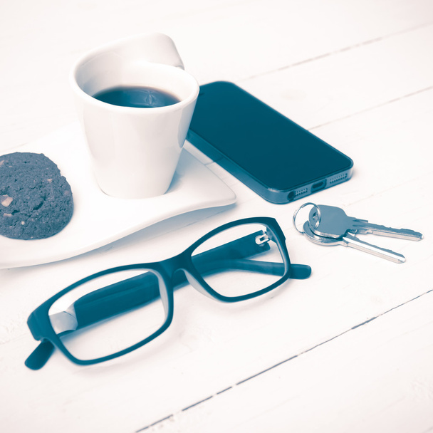 coffee cup with cookie,phone,eyeglasses and key vintage style - Фото, изображение