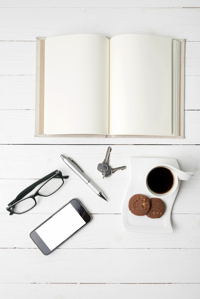 coffee cup with cookie,phone,open notebook,key and eyeglasses - Fotó, kép