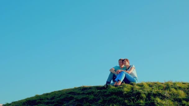 para siedzi na trawie, na wzgórza - Materiał filmowy, wideo