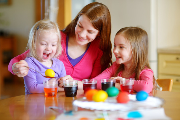 mother and  daughters painting  Easter eggs - Photo, image