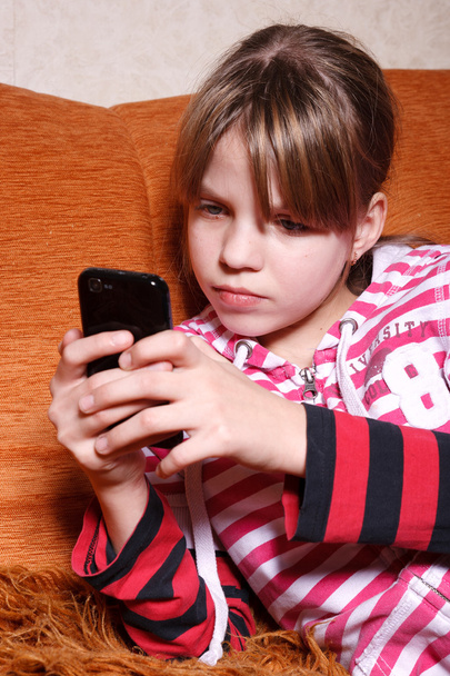 A very serious girl playing games on phone - Valokuva, kuva
