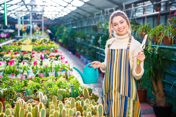Mujer feliz jardinero sosteniendo pala de jardín y regadera
  - Foto, imagen