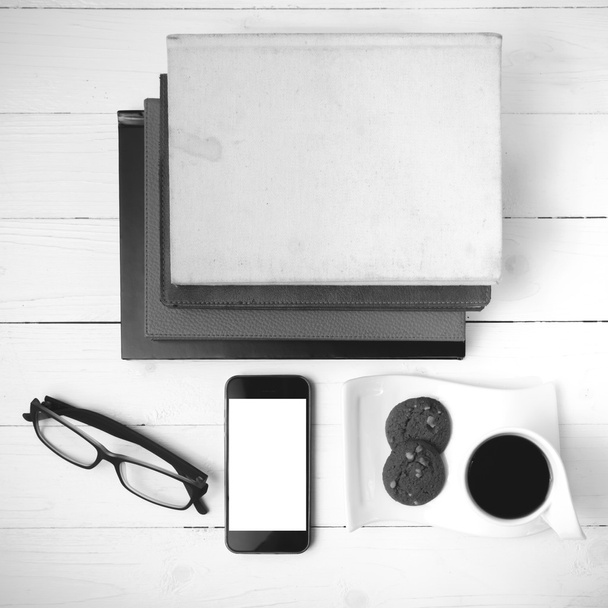 coffee cup with cookie,phone,stack of book and eyeglasses black  - Фото, зображення