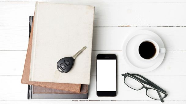 coffee cup with phone, car key,eyeglasses and stack of book - Foto, imagen