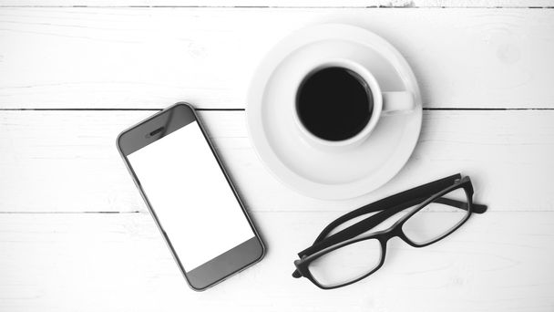 šálek kávy s telefonem a brýle černé a bílé barvy - Fotografie, Obrázek