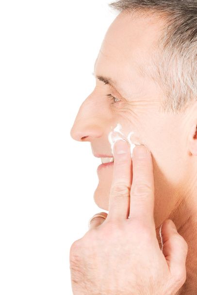 Man applying cream on his face - 写真・画像