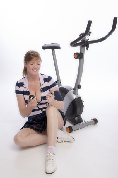 Femme vérifiant la pression artérielle après avoir fait du vélo d'appartement
 - Photo, image
