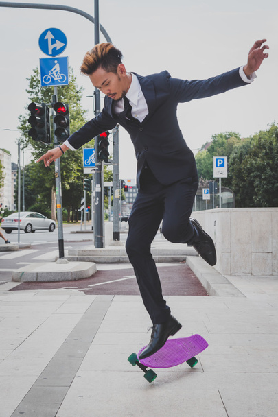 Young handsome Asian model jumping with his skateboard - Φωτογραφία, εικόνα