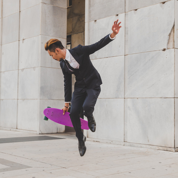 Молодий красивий азіатська модель стрибки з його скейтборді - Фото, зображення