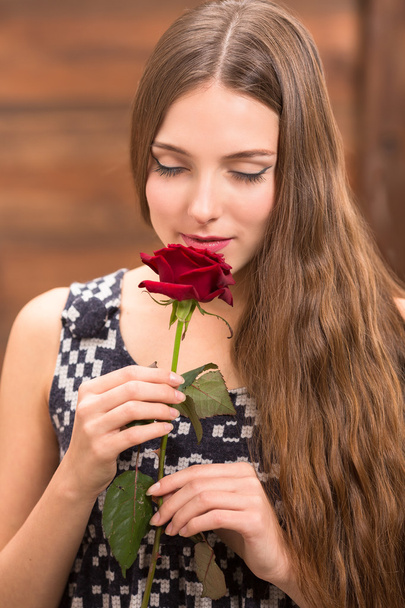 Kaunis tyttö poseeraa punainen ruusu
 - Valokuva, kuva