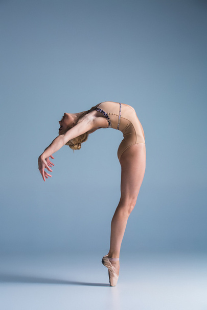 Young beautiful modern style dancer posing on a studio background - Foto, afbeelding