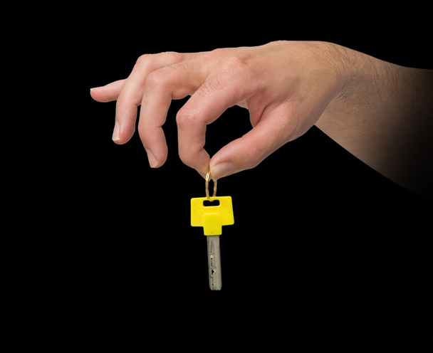 Hand holding key with yellow bow - Zdjęcie, obraz