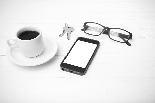 coffee cup with phone, eyeglasses and key black and white color - Foto, Imagen