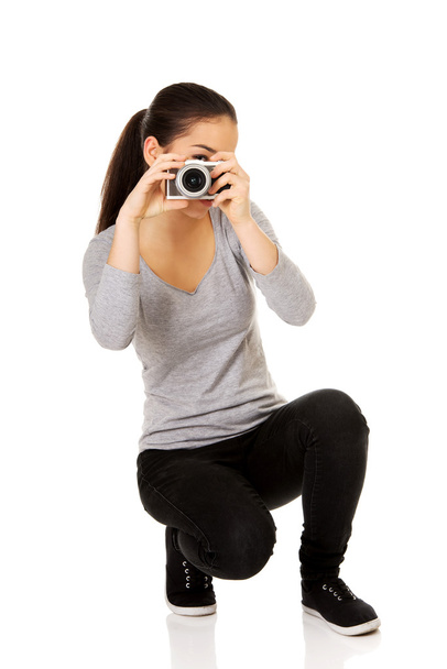 Woman taking a photo with a camera. - Фото, зображення