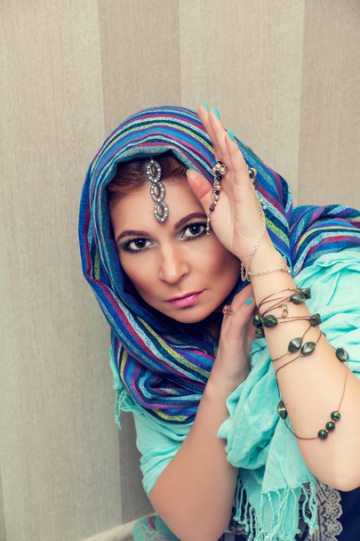 Beautiful oriental woman in a traditional headscarf. - Fotó, kép
