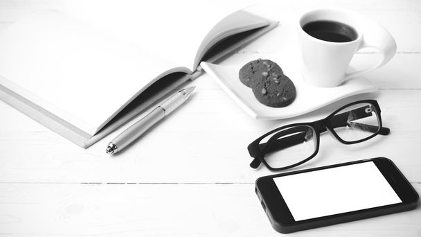 coffee cup with cookie,phone,notebook and eyeglasses black and w - Fotó, kép