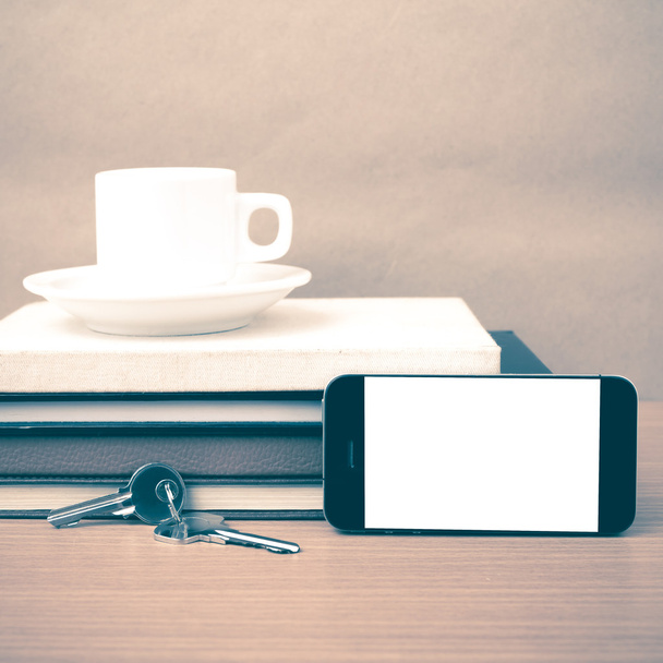 coffee cup with phone key and stack of book - Фото, изображение