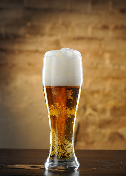Beer into glass on a old stone - Photo, Image