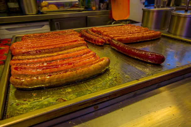Vienna, Austria - 11 August, 2015: Closeup of classic Austrian bratwurst sausages lying on heated metal surface, display for customers - Foto, imagen