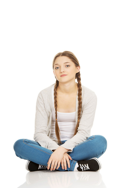 Happy teen woman sitting cross legged. - Fotografie, Obrázek