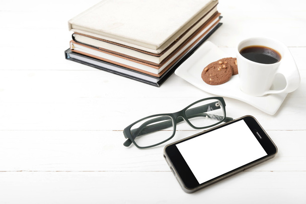 coffee cup with cookie,phone,stack of book and eyeglasses - Photo, image