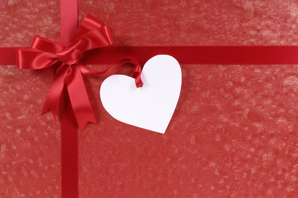 rotes Valentinstagsgeschenk, weißes Herzförmiges Geschenkanhänger oder -etikett, Kopierraum - Foto, Bild