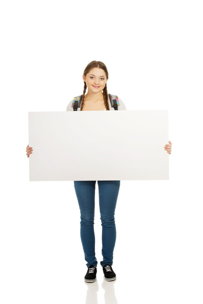 Young woman with blank billboard. - Zdjęcie, obraz