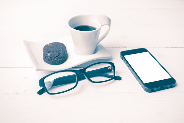 coffee cup with cookie,phone and eyeglasses vintage style - Фото, изображение