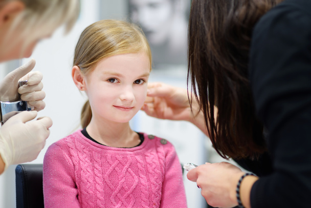 little girl having ear piercing - Fotografie, Obrázek