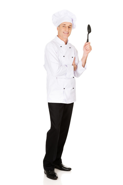 Chef holding black plastic spoon - Fotografie, Obrázek