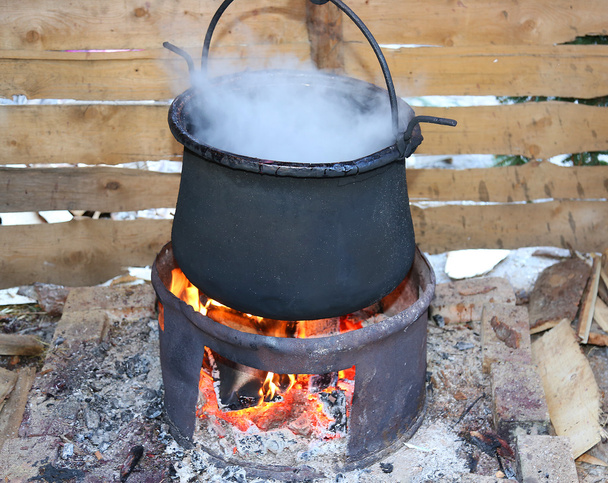 big black pot with the fire lit - Photo, Image