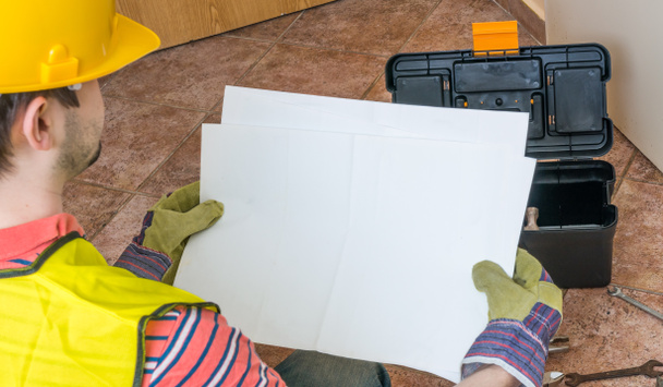 Εργαζόμενος κρατά κενό χαρτί ως ένα πλαίσιο για το προσαρμοσμένο μήνυμα. - Φωτογραφία, εικόνα