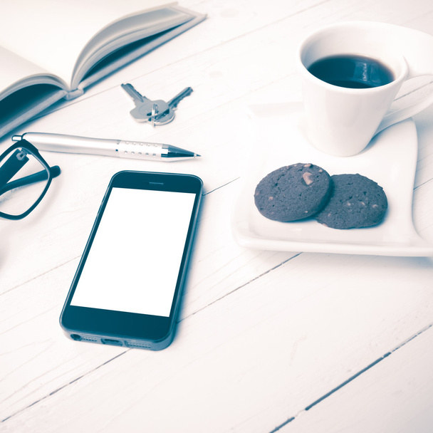 coffee cup with cookie,phone,open notebook,key and eyeglasses vi - 写真・画像
