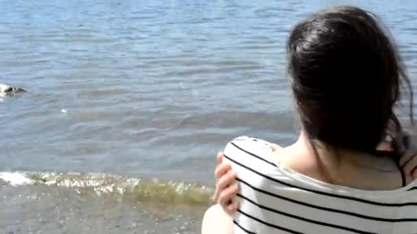 dziewczyna siedzi na brzegu okazuje i uśmiechy - Materiał filmowy, wideo