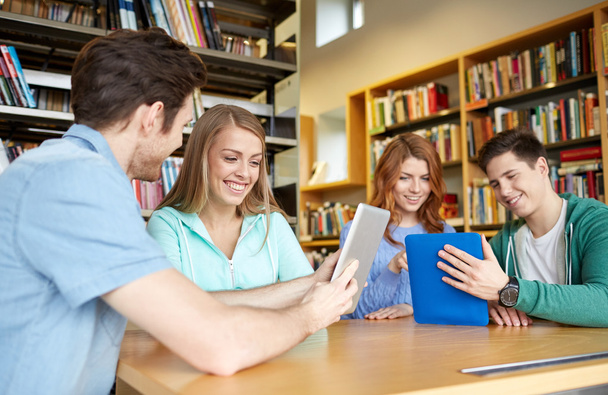 happy students with tablet pc in library - Фото, зображення
