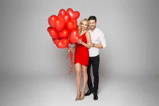 Happy beautiful couple posing and holding balloons - Fotó, kép
