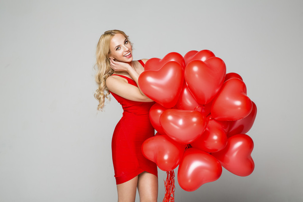 Beautiful smiling blond woman posing and holding balloons - Foto, imagen